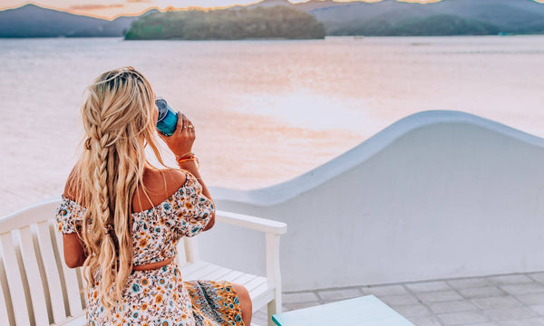 Woman looking at the horizon drinking from a Cup