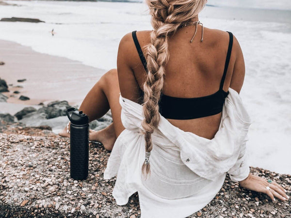 Woman at the beach with a water bottle